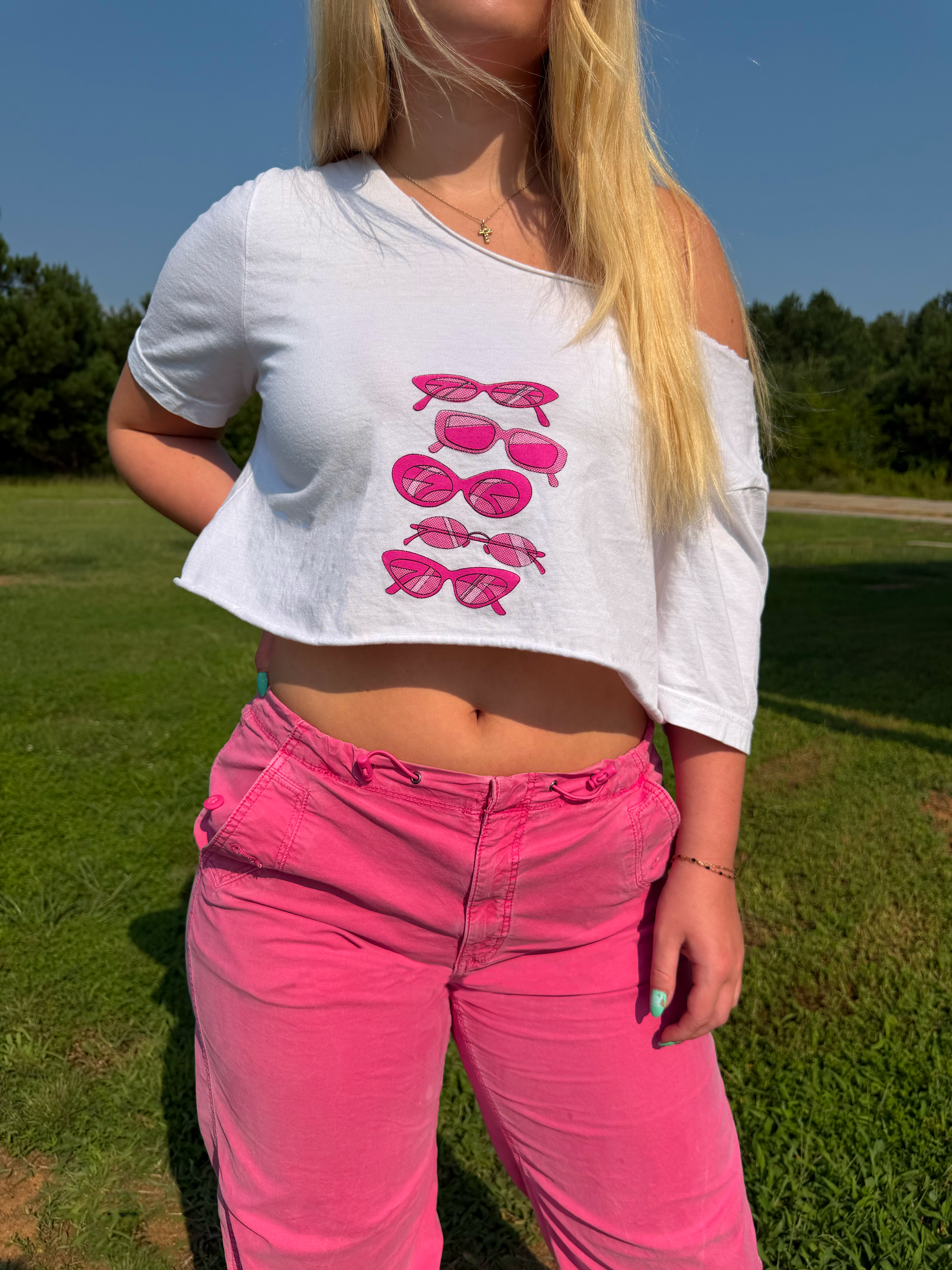 White cropped T-shirt with a bright pink stacked sunglasses screen print